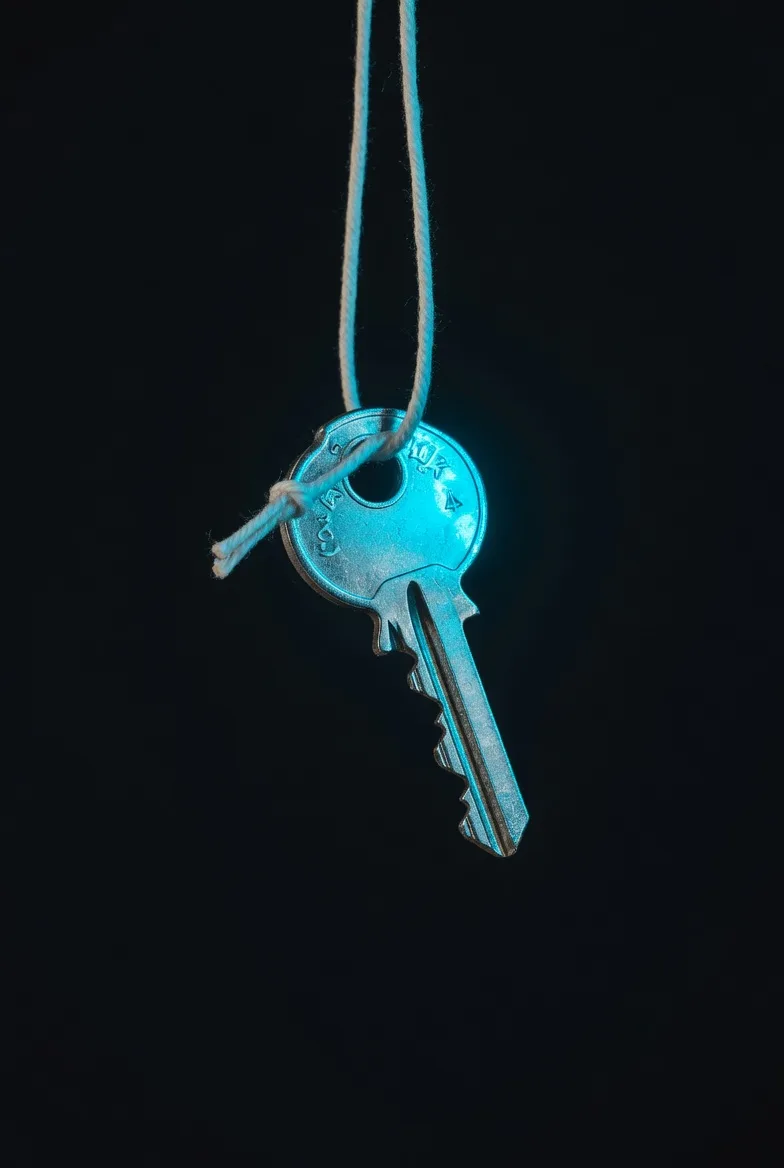 Minimalist silver house key glowing with neon cyan, representing self-sovereignty